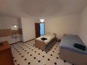 a bedroom with two beds and a tiled floor at Maison chaleureuse in Rustrel