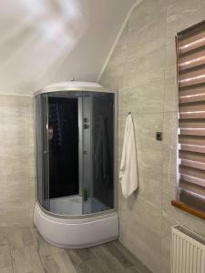 een badkamer met een douche en een spiegel bij Зруб in Skhidnitsa +23 foto's