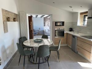 a kitchen with a table and chairs in a room at Maison chaleureuse avec parking sur place in Saint-Gelais