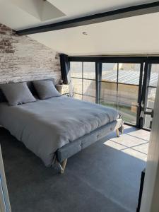a bed in a room with a brick wall at Maison chaleureuse avec parking sur place in Saint-Gelais