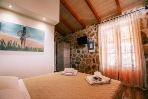 a bedroom with a bed and a painting on the wall at Dreamy Stone House in Pesádha