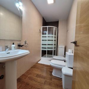 a bathroom with two toilets and a sink and a shower at "El Torreón" en el centro histórico de Baeza in Baeza