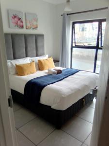 a bedroom with a large bed with yellow pillows at The Blyde in Pretoria
