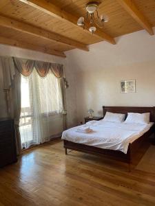 een slaapkamer met een groot bed en een groot raam bij Зруб in Skhidnitsa