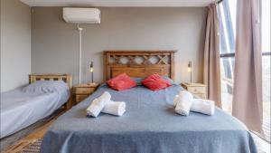a bedroom with a blue bed with red and white pillows at Las Crucesita wine lodge in Las Compuertas +25 photos