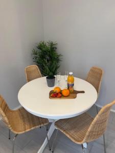 una mesa blanca con naranjas y bebidas. en Romslig leilighet sentralt i Svolvær sentrum, en Svolvær