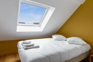 een slaapkamer met een wit bed en een raam bij Modern and design duplex in Lambersart close to Lille center - Welkeys in Lambersart