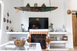 uma sala de estar com lareira e televisão em Um Lugar ao Sol Beach House Azenhas do Mar em Sintra