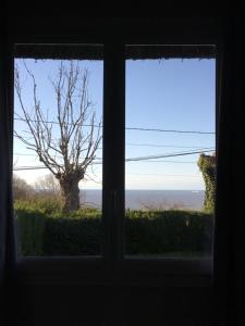 ヴィレルヴィルにあるLa Renardièreの木と海の景色を望む窓