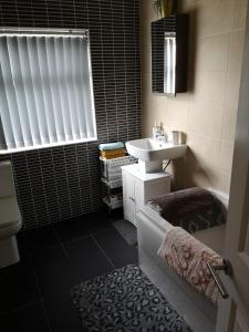 een badkamer met een wastafel, een toilet, een bad en een wastafel bij A home away from home now with Netflix and PS4 in Blackpool