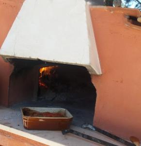 a woodburning oven with a bowl of food in it at Villa Indipendente Superior "Fanfan" con ampio Giardino e Piscina in Terlizzi +14 photos