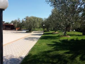 a park with green grass and trees and a street at Villa Indipendente Superior "Fanfan" con ampio Giardino e Piscina in Terlizzi
