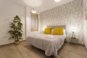 sypialnia z łóżkiem z żółtymi poduszkami i rośliną w obiekcie Catedral VIEW Apartment by Cadiz4Rentals w Kadyksie