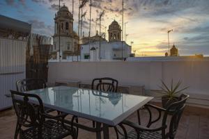 szklany stół i krzesła na balkonie z budynkiem w obiekcie Catedral VIEW Apartment by Cadiz4Rentals w Kadyksie
