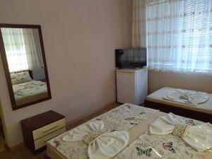 a small room with a bed and a mirror at Фамилна къща Джоко in Kiten