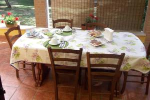 una mesa con un mantel blanco y sillas con comida. en B&B Al Castagneto, en Valmontone