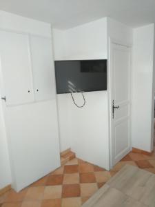 um quarto com uma televisão na parede e uma porta em La Terrasse em Mers-les-Bains