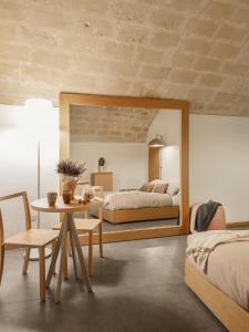 Schlafzimmer mit einem Bett, einem Tisch und einem Spiegel in der Unterkunft San Giovanni Vecchio - Residenza in Matera