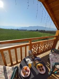 einen Tisch mit Speisen auf einem Balkon mit Aussicht in der Unterkunft Chalet le Clos de l'Orme in Saint-Lattier