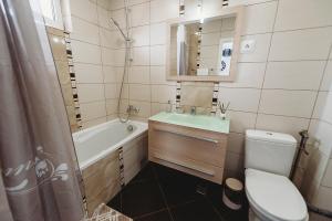 a bathroom with a tub and a toilet and a sink at Apartament Alex in Sibiu +26 photos