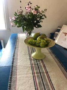 einen Obstteller auf einem Tisch mit einer Blumenvase in der Unterkunft Seaside Cottage Haga Park in Fröbygårda