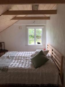 a bedroom with a large bed with a window at Seaside Cottage Haga Park in Fröbygårda