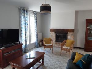 a living room with a couch and a tv at maison de vacances Périgord noir in Terrasson-Lavilledieu