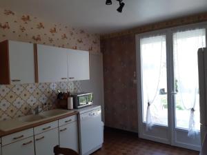 a kitchen with white cabinets and a sink and a window at maison de vacances Périgord noir in Terrasson-Lavilledieu