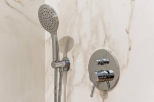 un soffione doccia e uno specchio in bagno di Serenata Boutique Rooms a Porto