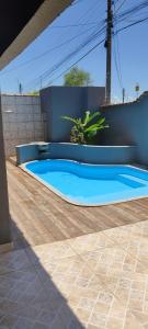 a large blue swimming pool with a wooden floor at Casa 3/4 com piscina e mesa de sinuca em Caldas Novas in Caldas Novas