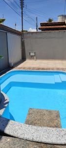 a large blue swimming pool in a yard at Casa 3/4 com piscina e mesa de sinuca em Caldas Novas in Caldas Novas