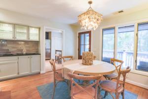 a dining room with a table and chairs and a chandelier at Riverhouse in Johns Island +42 photos