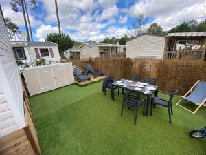 a backyard with a table and chairs and a fence at Coeur Des Sables in Saint-Julien-en-Born