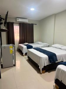 Pokój z 3 łóżkami i telewizorem w obiekcie Tropical Dreams w mieście San Andrés