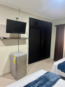 um quarto com uma porta preta e uma televisão na parede em Tropical Dreams em San Andrés