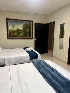 a bedroom with two beds and a painting on the wall at Tropical Dreams in San Andrés