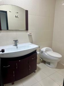 a bathroom with a sink and a toilet and a mirror at Tropical Dreams in San Andrés