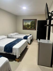 a hotel room with three beds and a flat screen tv at Tropical Dreams in San Andrés