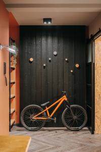 una bicicleta naranja estacionada frente a una pared negra en Apartament Riders Lodge Bielsko-Biała Jeżynowa en Bielsko-Biala