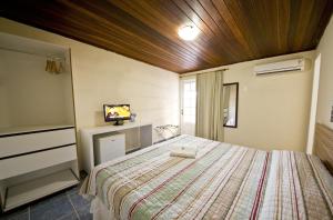 una camera con un letto e una televisione di Sol Nascente Hotel Pousada Beira Mar a Natal