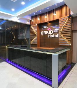 a hotel lobby with a black counter and a hotel sign at Orkid Hills Hotel in Kuala Lumpur