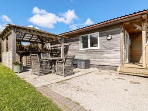 a patio with chairs and a table in front of a house at Lowena in Saint Day