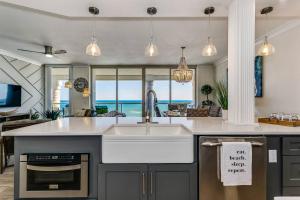 a kitchen with a sink and a kitchen with the ocean at Beach Club 604 in Pensacola Beach