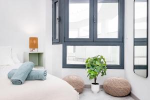 sypialnia z łóżkiem i dwoma oknami w obiekcie BHost - La Muralla w mieście Tarifa