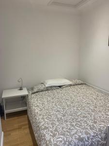 uma cama num quarto branco com uma mesa em Beautiful one bedroom flat in the heart of Notting Hill Gate em Londres