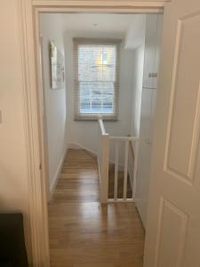 a hallway with a stair case and a window at Beautiful one bedroom flat in the heart of Notting Hill Gate in London