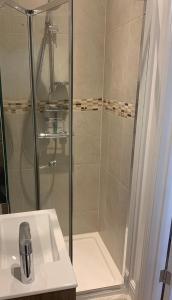 a shower with a glass door next to a sink at Beautiful one bedroom flat in the heart of Notting Hill Gate in London
