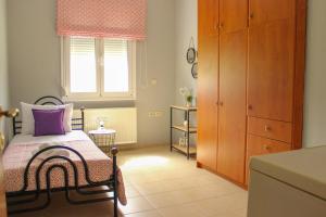 Schlafzimmer mit einem Bett und einem Fenster in der Unterkunft Country House Crete in Amnátos