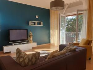 uma sala de estar com um sofá e uma televisão de ecrã plano em Alle Porte di Assisi Holiday Home em Assisi