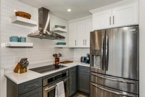 a kitchen with a stainless steel refrigerator and white cabinets at Beach Club 604 in Pensacola Beach +42 photos